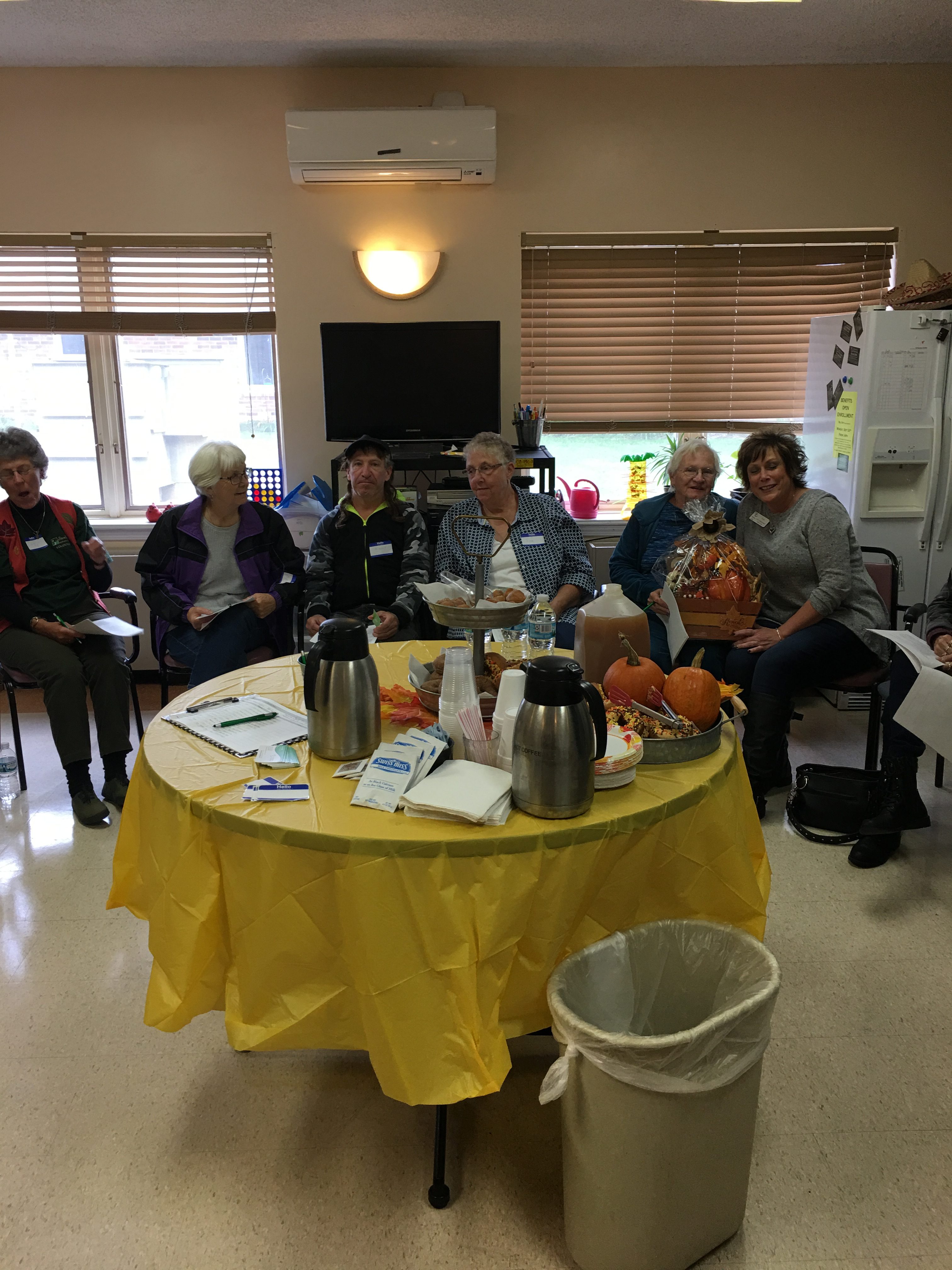 residents and staff sitting around table with pumpkins